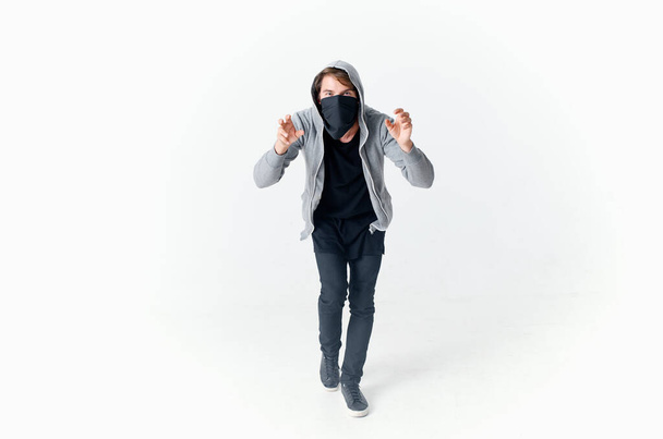 un uomo in passamontagna con un cappuccio anonimato crimine luce sfondo - Foto, immagini