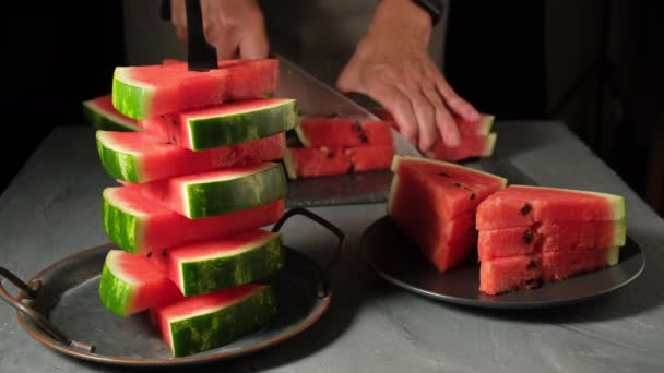 Blanke vrouw snijdt plakjes rijpe watermeloen met mes en doet er een kom in. Gezond voedsel concept, seizoensfruit, zomerfeest, snacks. - Video