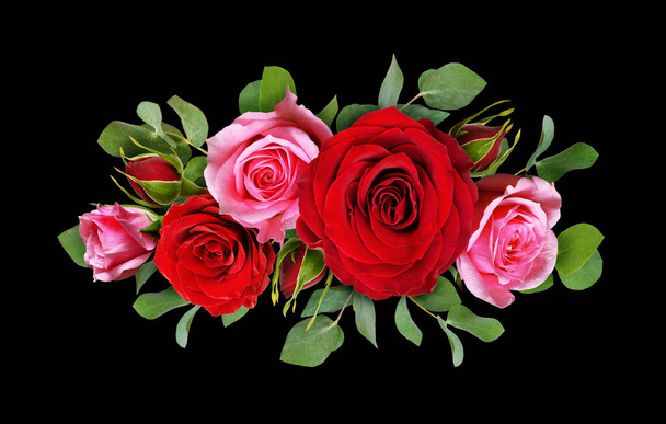 Red and pink rose flowers with eucalyptus leaves in a floral arrangement isolated on black background. Flat lay. Top view. - Photo, image