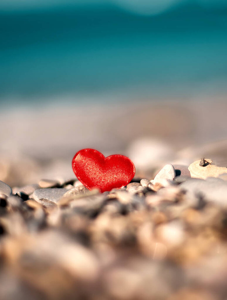 corazones rojos sobre piedras sobre un fondo borroso junto al mar. Símbolo de amor - Foto, imagen