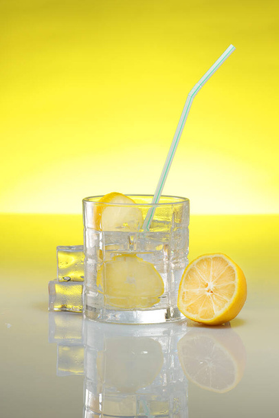 drink with lemon and ice on a yellow background - Photo, Image