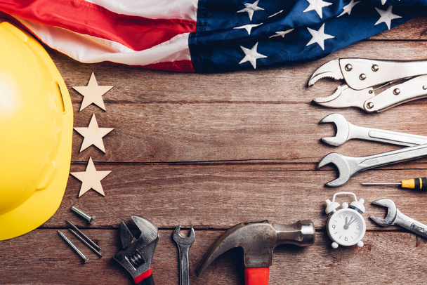 USA Labor day concept, Top view flat lay of different kinds wrenches with American flag on wood table. First Monday in September, creation of labor movement and dedicated to social of American worker - Фото, изображение