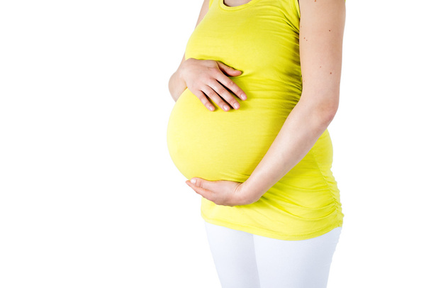 zwangere buik met handen op het - Foto, afbeelding