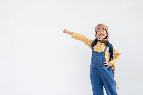 Sny o útěku! malé dítě dívka hrát s pilotním kloboukem na bílém pozadí - Fotografie, Obrázek
