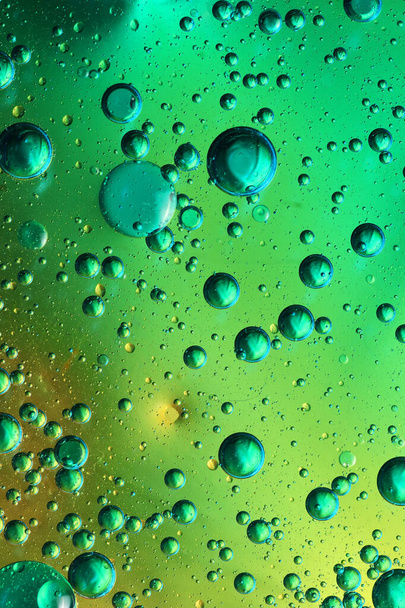 bulles d'huile avec de l'eau sur verre et fond coloré - Photo, image