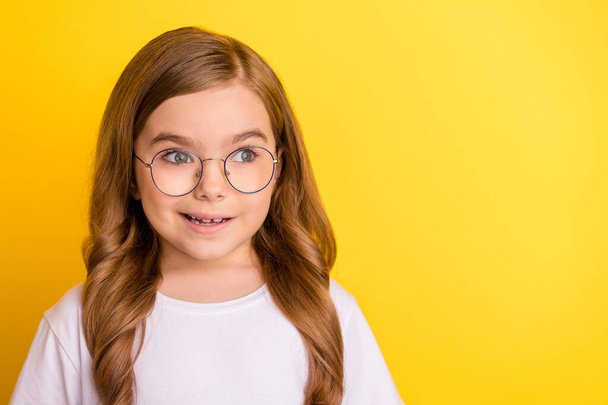 Photo of young school girl happy positive smile amazed surprised look empty space isolated over yellow color background - Zdjęcie, obraz