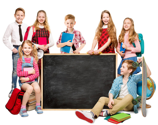 Eine Gruppe glücklicher Schulkinder neben der Tafel. Kinder lernen und zurück in die Schule. Grundschüler über isolierten weißen Studiohintergrund - Foto, Bild