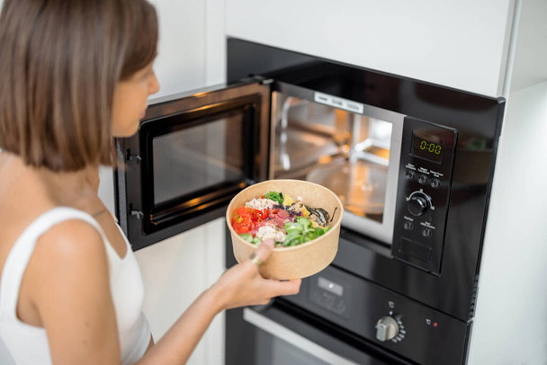 Woman heating food with microwave machine - Zdjęcie, obraz