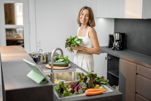 Femme cuisine avec des légumes frais et des légumes verts dans l'évier - Photo, image