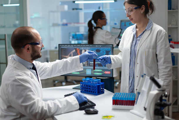 Équipe de microbiologie travaillant à l'expérience de biochimie analysant le test sanguin - Photo, image