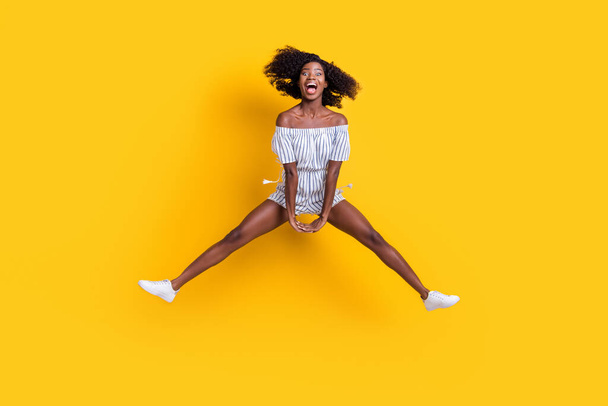 Full length body size view of attractive cheerful crazy ecstatic fit girl jumping having fun good mood isolated over bright yellow color background - Photo, image