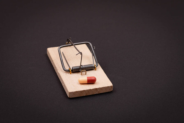 Colored Pill or Capsule in Wooden Mousetrap - Pharmaceutical Addiction - Foto, Bild