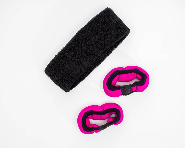 Sporteszközök halmaza sporttevékenységekhez, rózsaszín kézi súlyok és fekete fejpánt fehér háttér felülnézetben - Fotó, kép