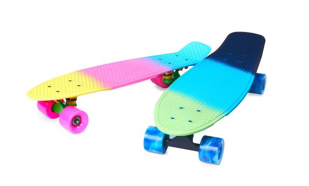 Twee regenboog plastic Penny board skateboards op witte achtergrond - Foto, afbeelding