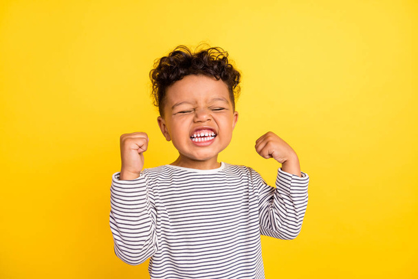 Photo portrait small boy gesturing like winner overjoyed isolated vivid yellow color background - Fotó, kép