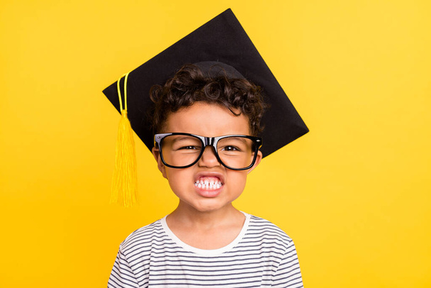 Photo portrait small boy wearing glasses student headwear showing teeth isolated vibrant yellow color background - Foto, Imagem