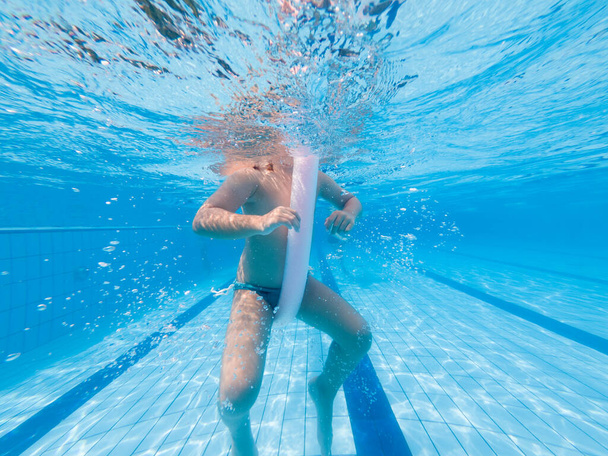 Child swimming on a swimming pool under water - Photo, Image