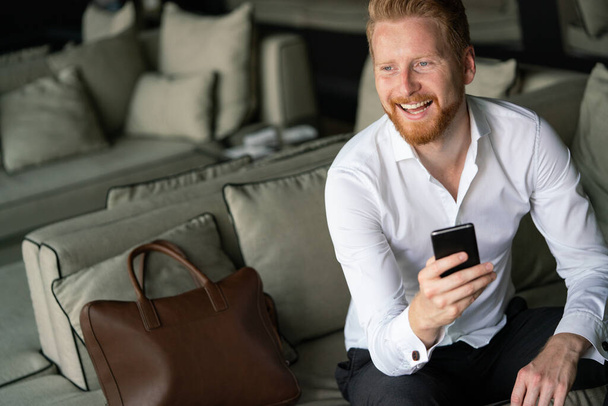 Portrait of handsome young businessman on a phone in the office - Fotoğraf, Görsel