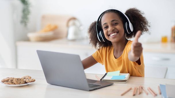 Positivo afroamericano adolescente chica disfrutando de la educación en casa - Foto, imagen