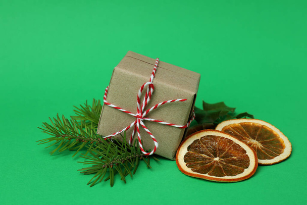 Gift box and Christmas accessories on green background - Photo, image