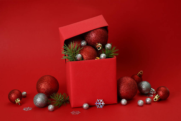ギフトボックスと赤い背景のクリスマスの赤ちゃん - 写真・画像