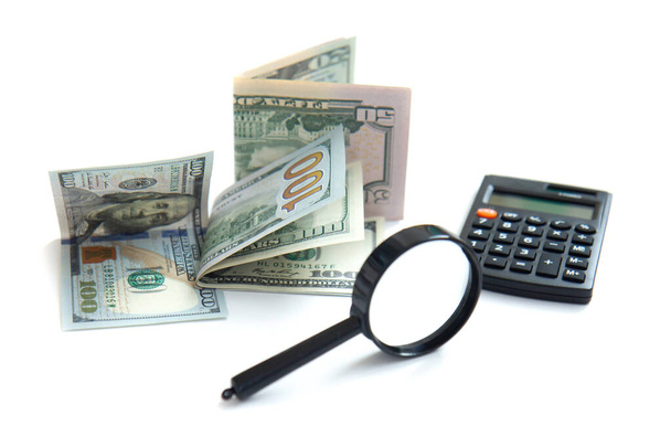 Lupe, Taschenrechner und Papiergeld isoliert auf weißem Hintergrund. Konzept: Geld behalten, investieren - Foto, Bild