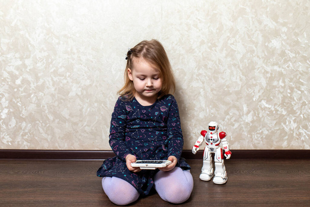 the child controls the robot from the remote control - Photo, Image