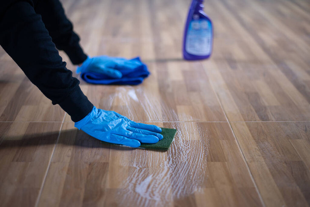 Les gens qui nettoient les carreaux de sol, près de la main nettoie une tache sur une tuile de sol avec un désinfectant. - Photo, image