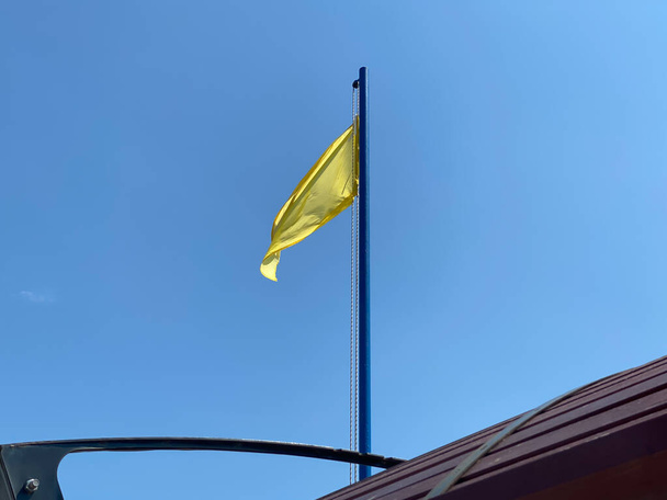 Bandiera gialla sulla spiaggia indica che è presente un bagnino. Il tetto è visibile. Cielo blu - Foto, immagini