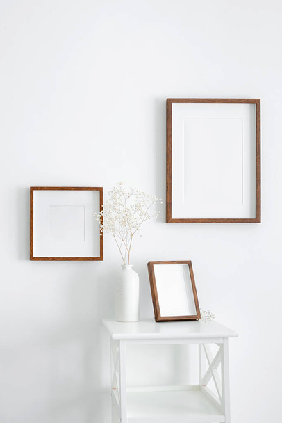 Frames mockup on white wall for photo or print presentation. Minimalistics style indoor interior with artwork mockup. - Photo, Image