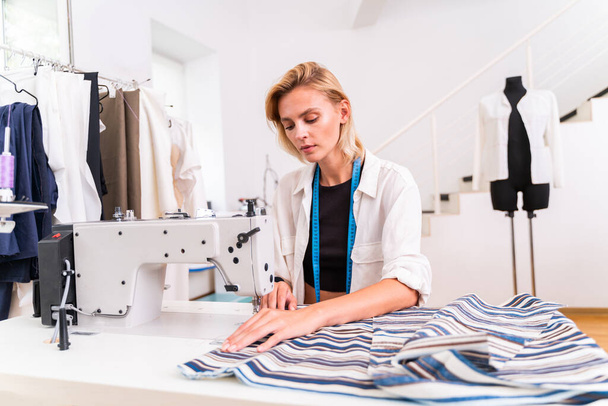 Fashion designer working in a clothing start-up workshop - Clothing tailor working on a new collection - Фото, изображение