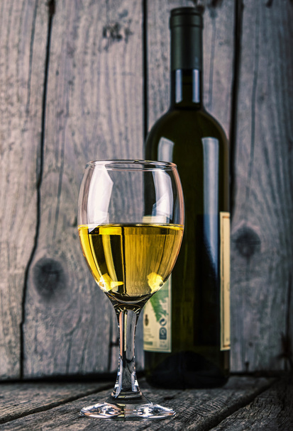 Бутылка белого вина и бокал вина на старом дереве
 - Фото, изображение