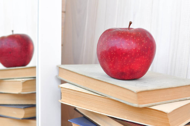 old thick textbook and red apple  on the school desk , knowledge concept, study hard - Foto, imagen