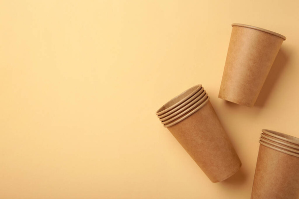 Disposable paper cups on beige background. Top view. - Valokuva, kuva