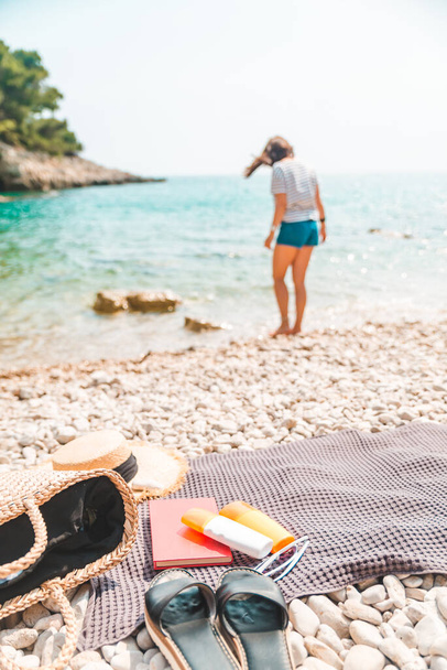 młoda ładna kobieta w letnim stroju spacery nad brzegiem morza koc z rzeczy plaży na koc letnie wakacje - Zdjęcie, obraz