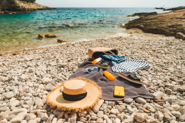 над головой вид на пляж вещи одеяло с солнцезащитным кремом соломенная шляпа с мешком плоский лежал - Фото, изображение