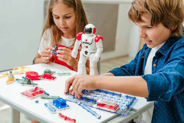 adolescent garçon et fille jouer avec robot pendant un cours dans l 'salle de classe. - Photo, image