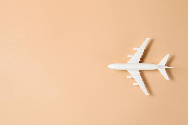 Flat lay design of travel concept with plane on brown background with place for text. - Zdjęcie, obraz