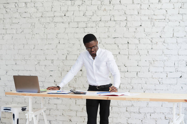 Mutlu Afrikalı Amerikalı adam müşteri ortaklarıyla video görüşmesi yapıyor. Genç siyah adam modern ofiste dizüstü bilgisayar kullanıyor. - Fotoğraf, Görsel