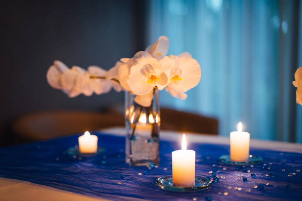 Bruiloft tafel decoraties met orchideeën, kaars licht - Foto, afbeelding