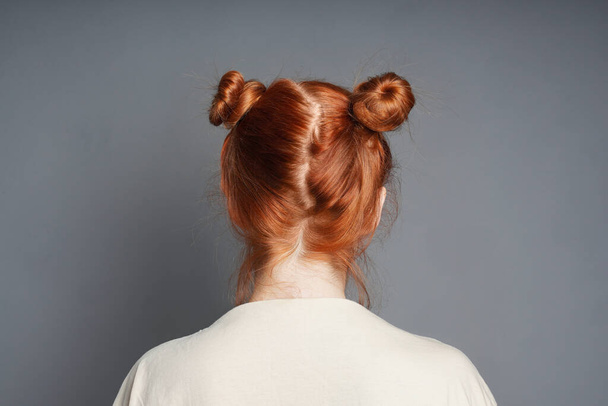 back view of red-haired woman with space buns hairstyle - Photo, Image