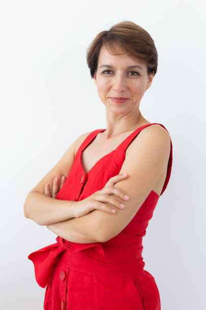 Confident business woman wearing red dress standing with crossed arms. Isolated portrait. - Фото, изображение