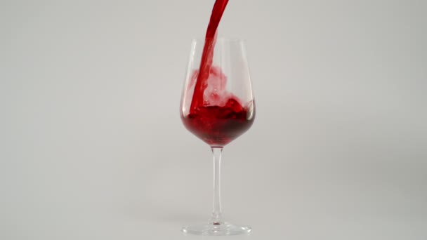 Αργή κίνηση του χύνοντας κόκκινο κρασί στο γυαλί σε 1000 fps, κόκκινο φόντο - Πλάνα, βίντεο