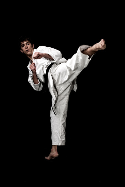 Karate macho luchador joven alto contraste sobre fondo negro
. - Foto, imagen