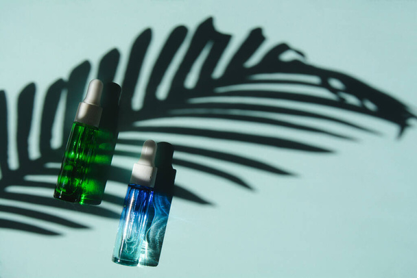 Liquid face serum in a glass bottles with a dropper. Essence of skin care for health and beauty. - 写真・画像