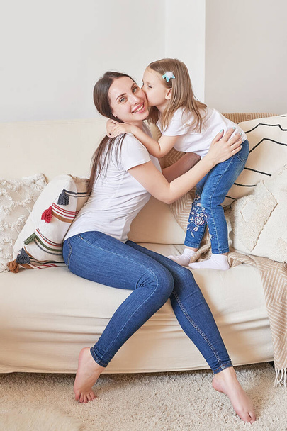 Happy family. Mother and daughter at home. Young woman and girl. Mothers and childrens day. Good morning and love concept. Light home interior. - Foto, Imagen