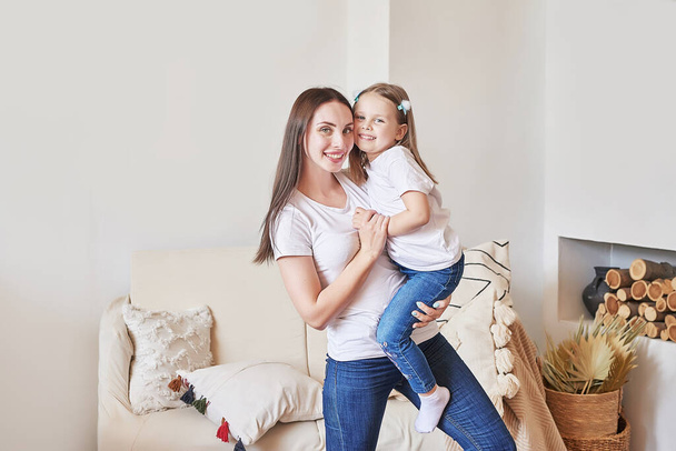 Happy family. Mother and daughter at home. Young woman and girl. Mothers and childrens day. Good morning and love concept. Light home interior. - Фото, зображення