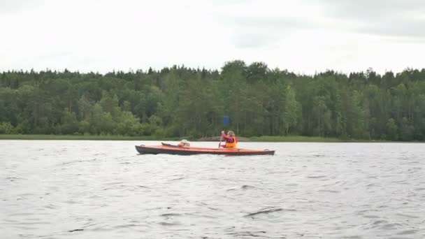 Mutter rudert Kajak mit Mädchen auf See in Waldnähe - Filmmaterial, Video