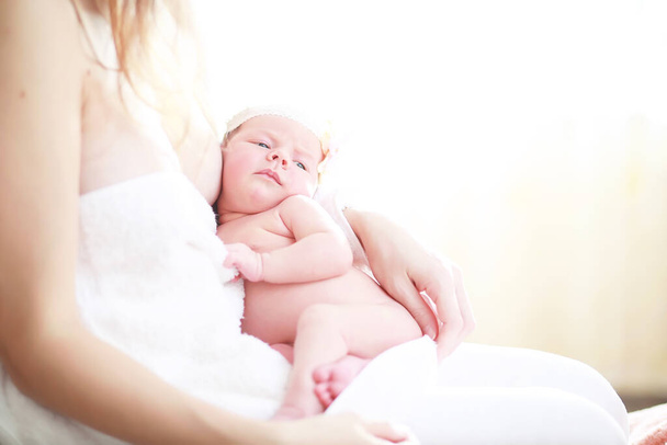 Um bebê recém-nascido está nos braços de sua mãe. Belo bebê da aparência europeia está dormindo. - Foto, Imagem