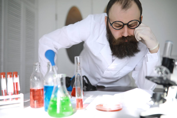 Chimico pazzo. Uno scienziato pazzo conduce esperimenti in laboratorio scientifico. Esegue la ricerca al microscopio. - Foto, immagini